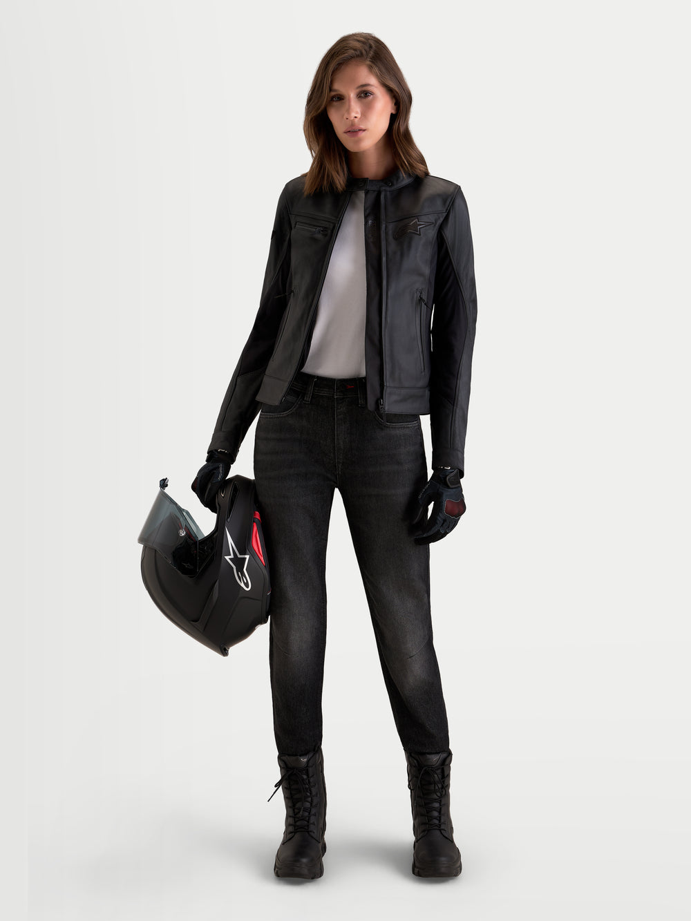 Alpinestars Stella Flex-AST 5 Denim Pants, women's urban contemporary motorcycle denim pants, Black Washed, featuring CE-rated A protection worn by a model holding a helmet and wearing matching riding jacket and boots