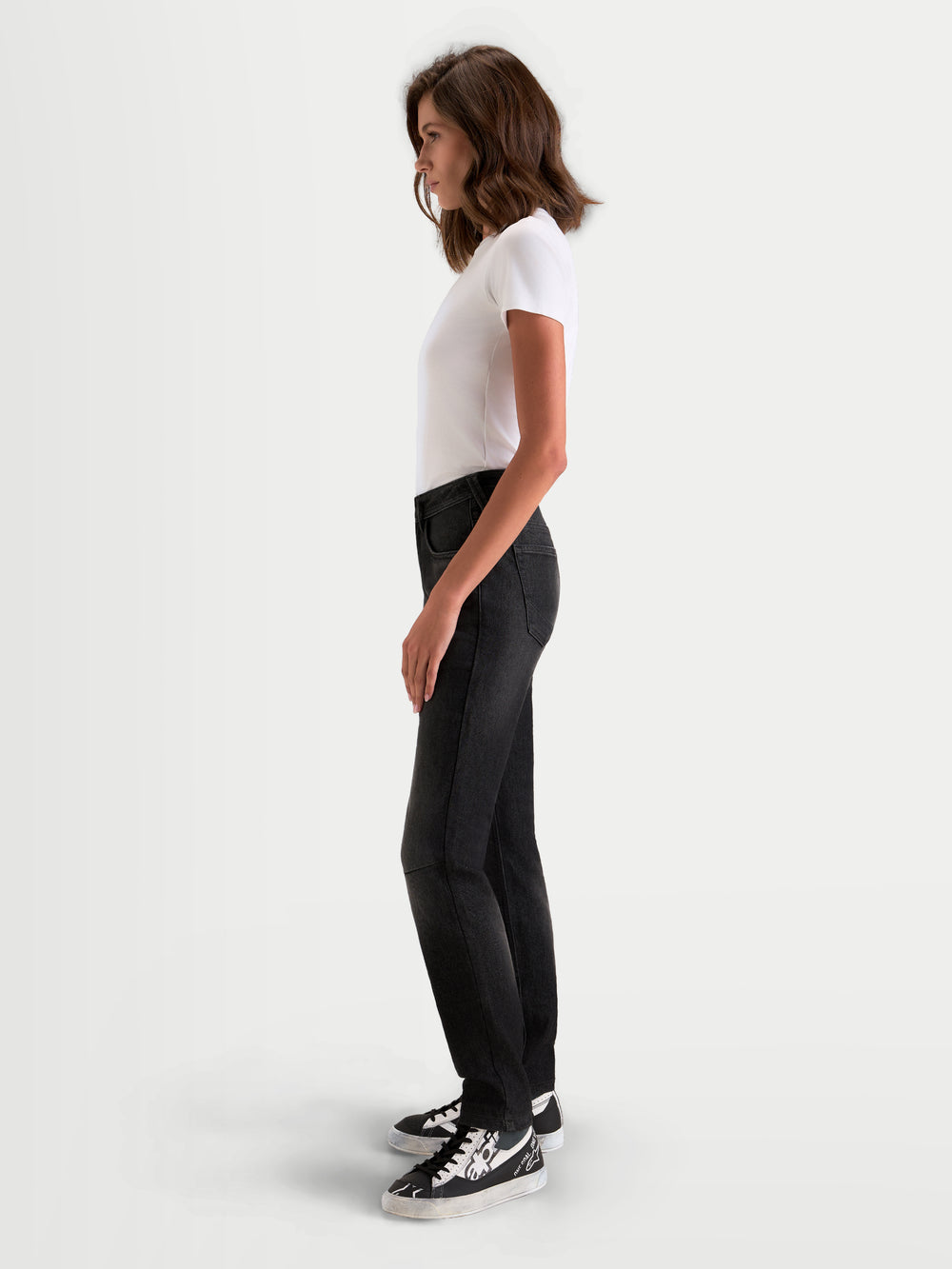 Alpinestars Stella Flex-AST 5 Denim Pants, women's urban contemporary motorcycle denim pants in black washed, side profile view on a model wearing casual riding apparel and sneakers, CE certified protection