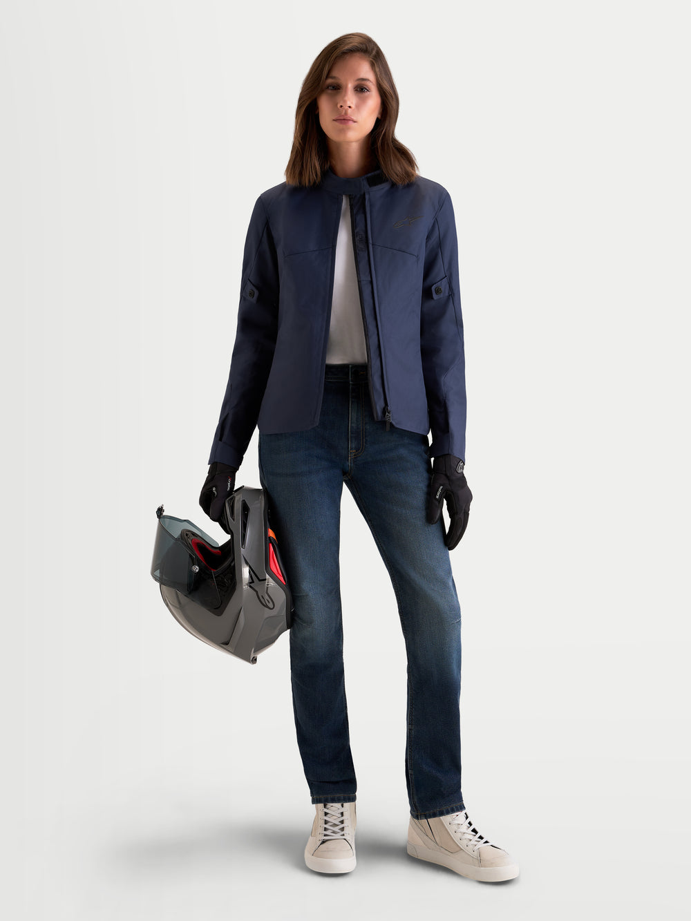 Alpinestars Stella Flex-AST 5 Denim Pants, women's urban motorcycle denim jeans in indigo washed blue, worn by a model holding a motorcycle helmet and matching riding gear, front view