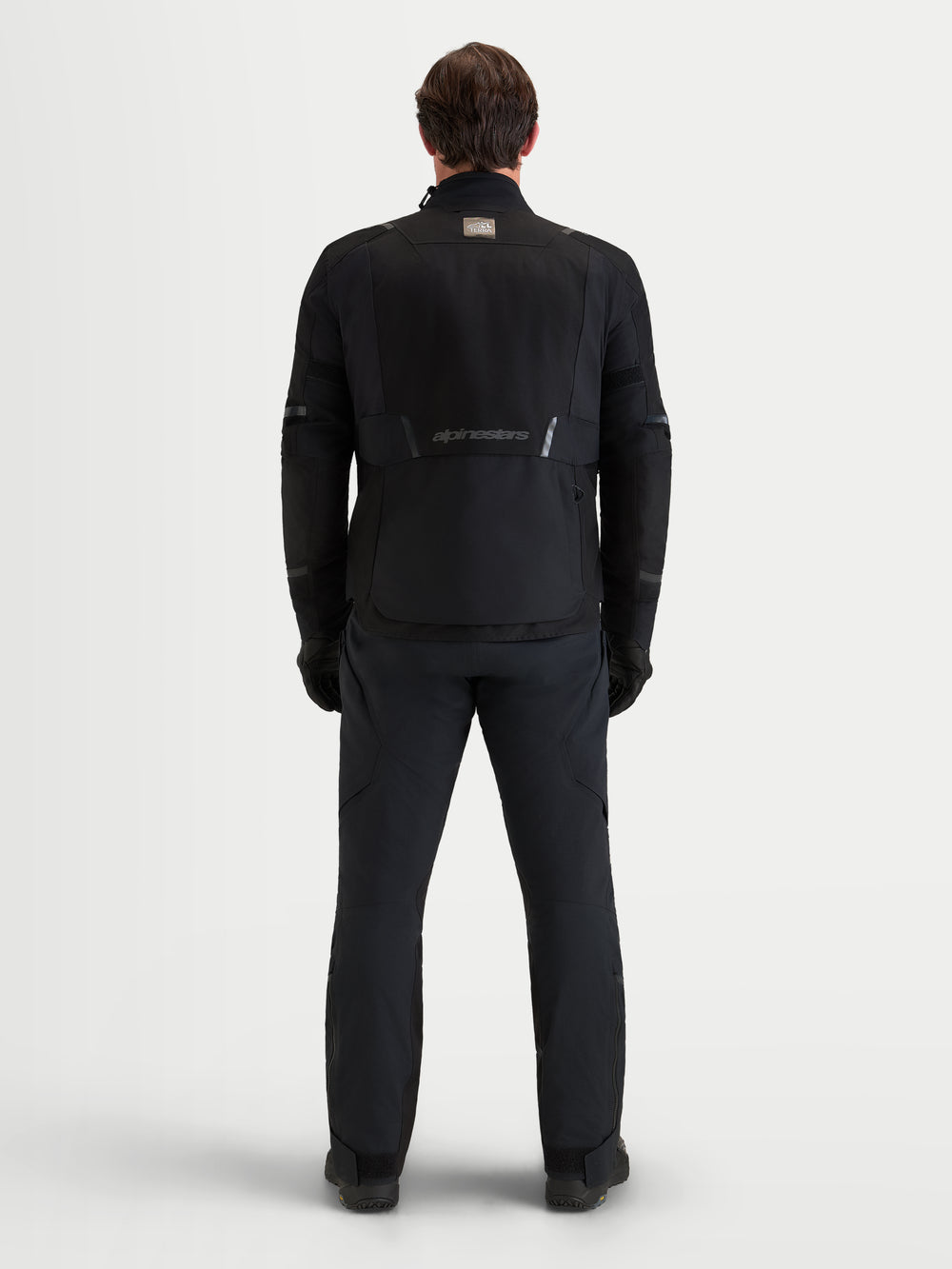 Alpinestars St-7 V2 2L Gore-Tex Jacket, men's all-terrain adventure motorcycle jacket in black, rear view showing technical waterproof textile construction and Alpinestars branding worn by a model