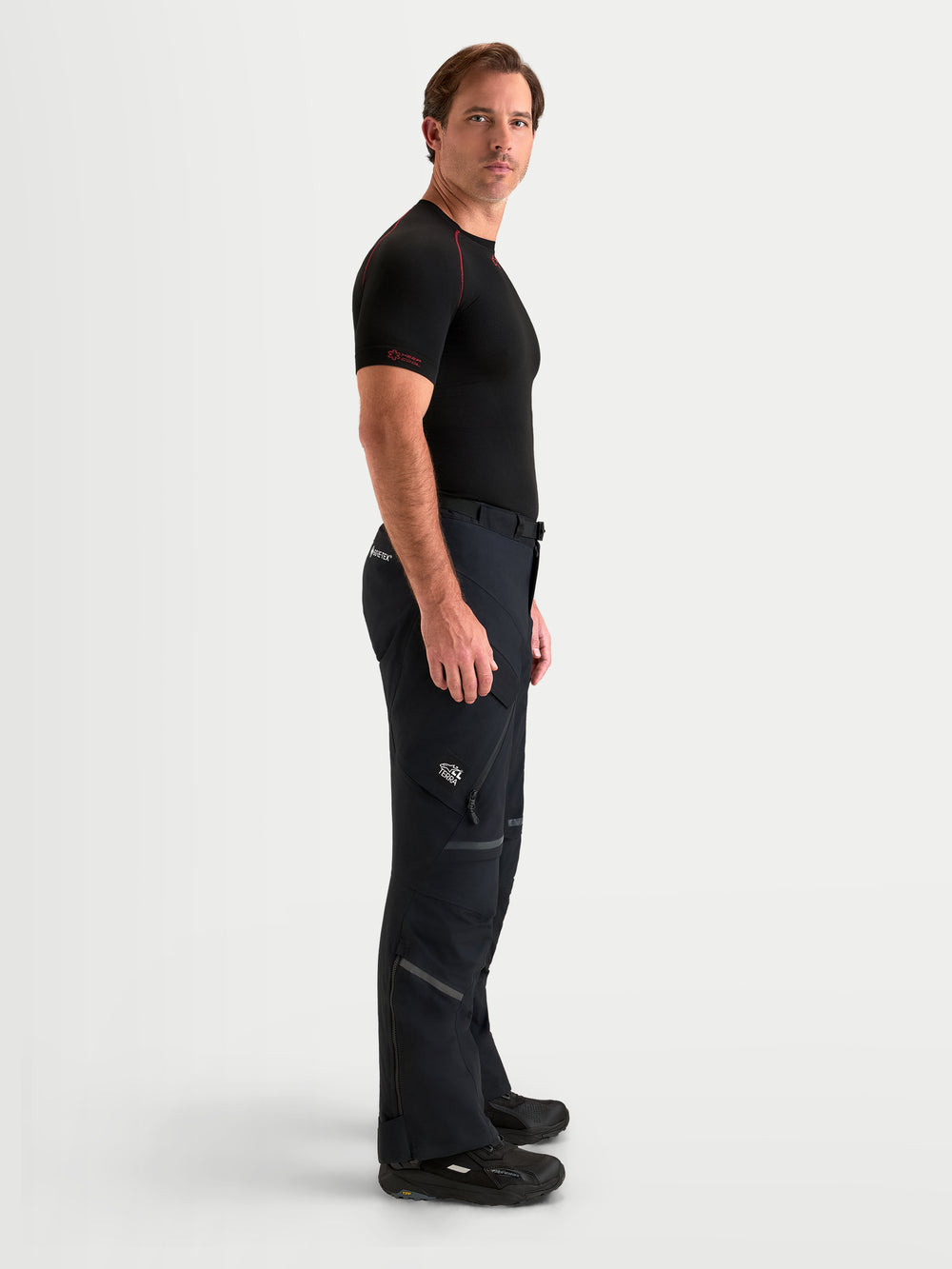 Alpinestars St-7 V2 2L Gore-Tex Pants, men's adventure touring motorcycle pants in black, side profile view worn by a model showing waterproof textile construction and cargo pockets.