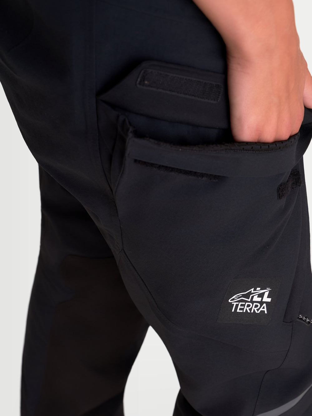 Alpinestars Stella ST-7 V2 2L Gore-Tex Pants Short, women's adventure touring motorcycle pants, black, close-up view showing waterproof cargo pocket and All Terra logo detail worn by a model