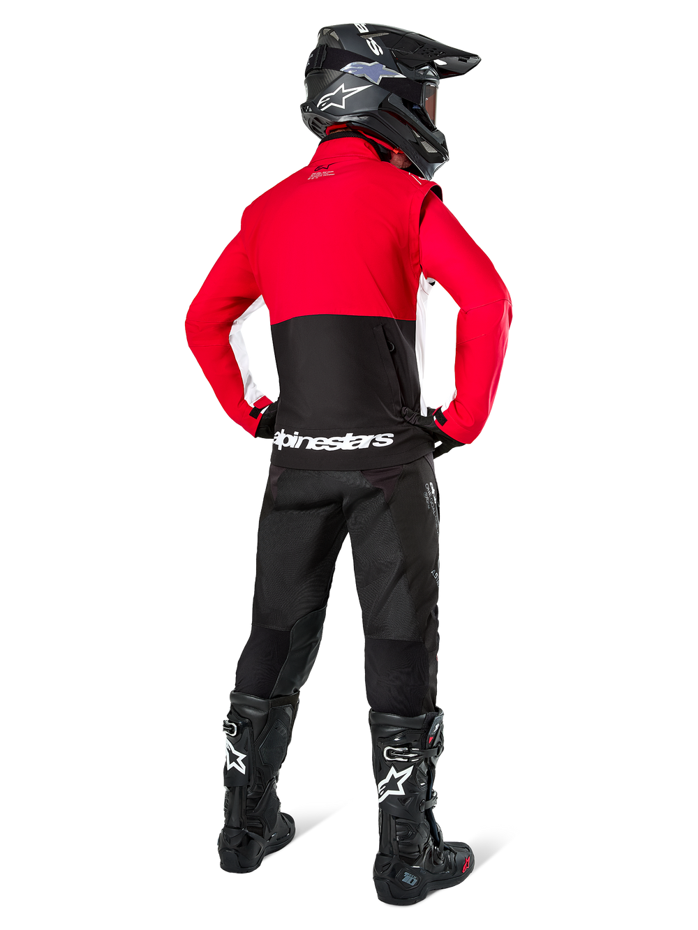 Motocross rider from behind wearing Alpinestars Lite-Dura Softshell Jacket, Black Bright Red and White, featuring a red upper panel and black lower section with white branding, paired with black pants, black helmet, and black boots, coordinated enduro outfit for off-road riding