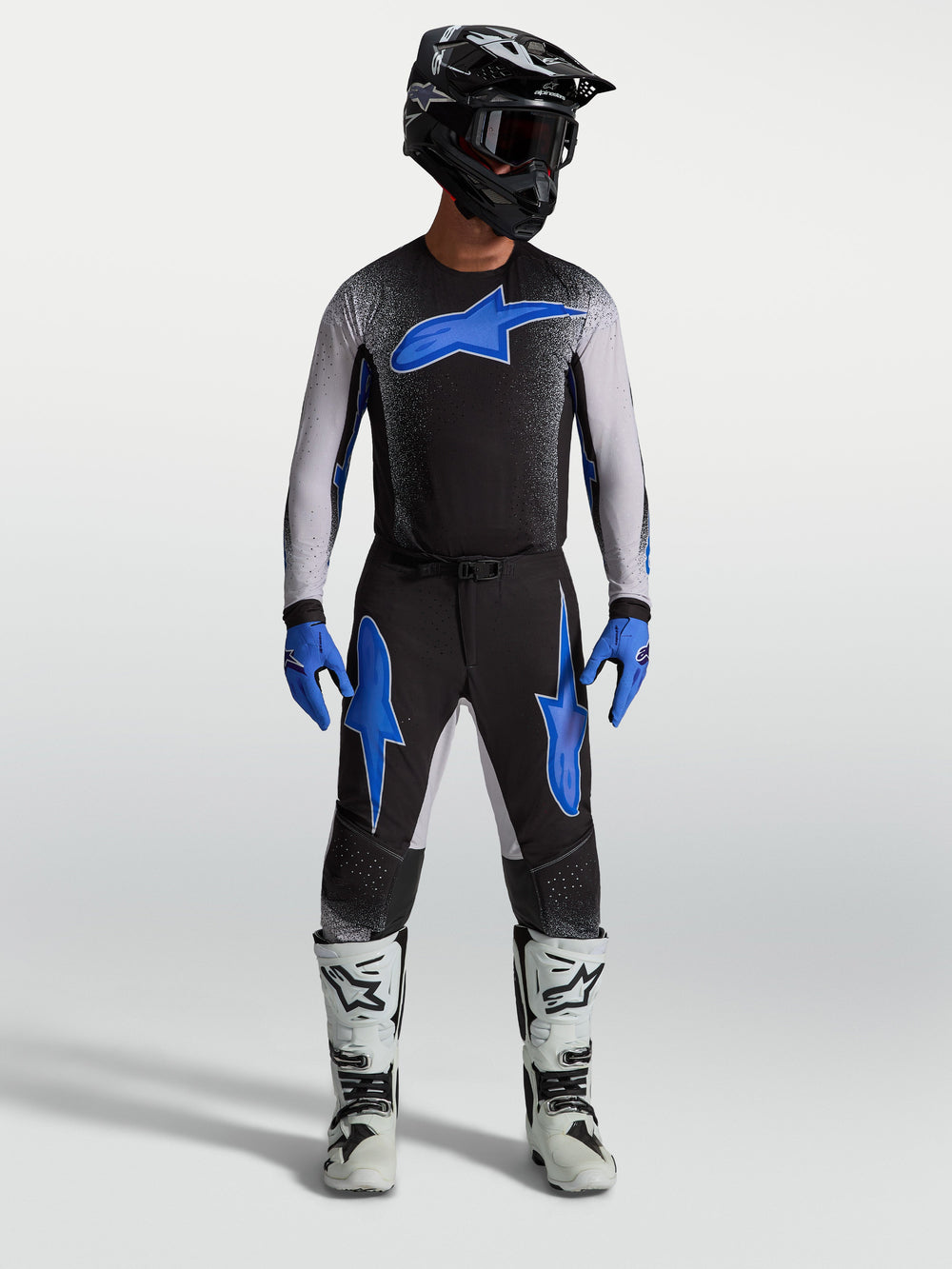 Alpinestars Supertech Hiten AFD Pants, black and blue motocross gear, on-model with matching jersey and white racing boots.