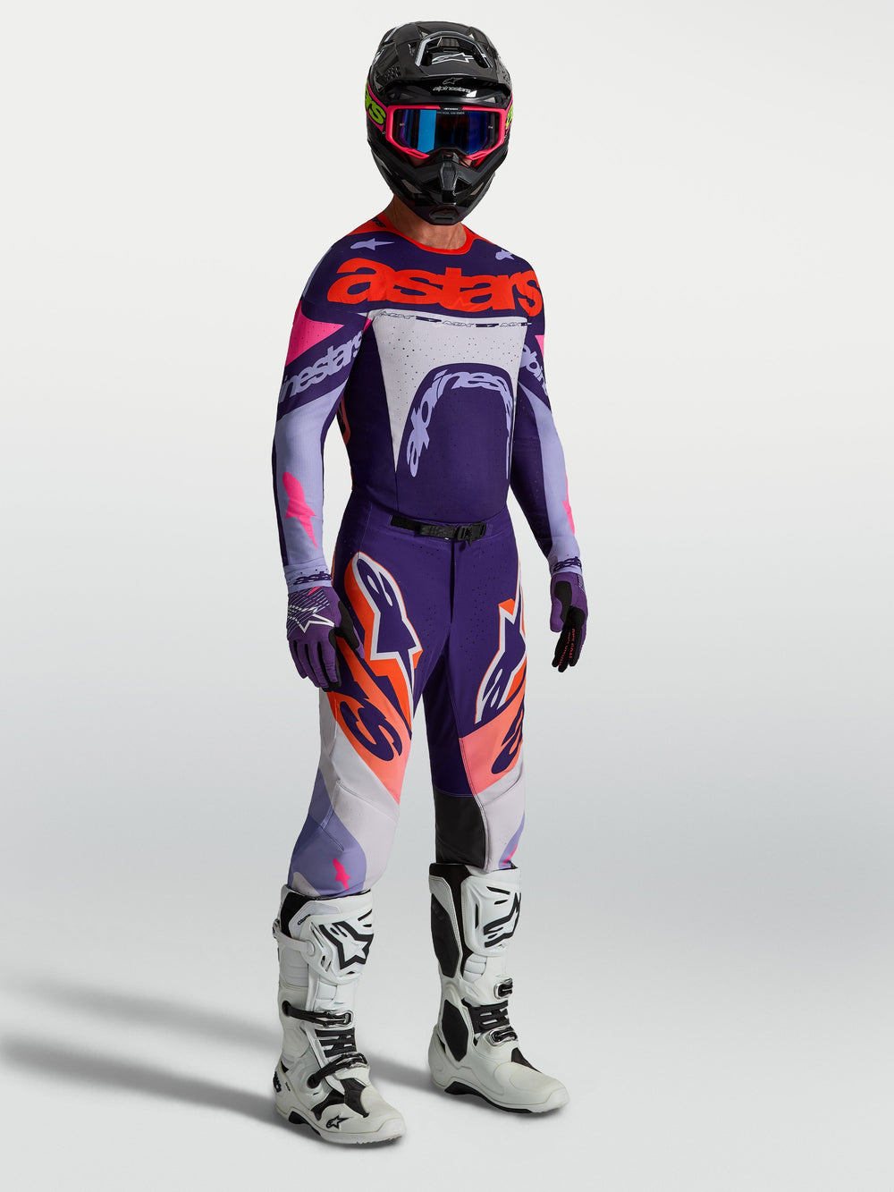 Alpinestars Supertech Dyna Pants in Purple and Pink Fluo, men's motocross gear with a matching jersey and white racing boots.