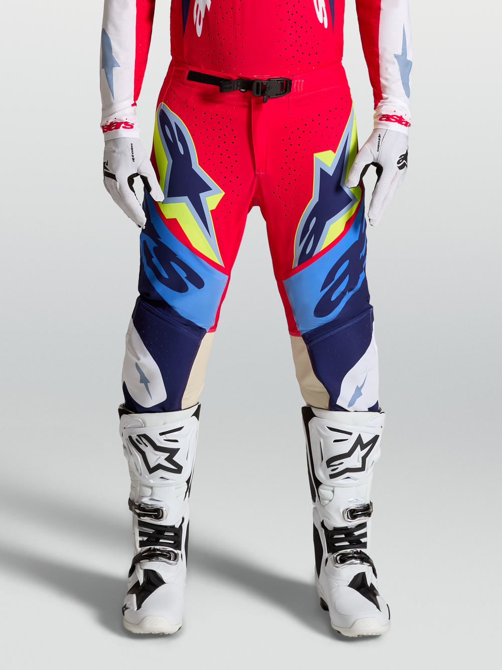 Alpinestars Supertech Dyna Pants, Motocross Racing Gear for Men, Fire Red and Navy Blue with White and Yellow accents, Featuring goat leather knee panels and magnetic buckle closure.