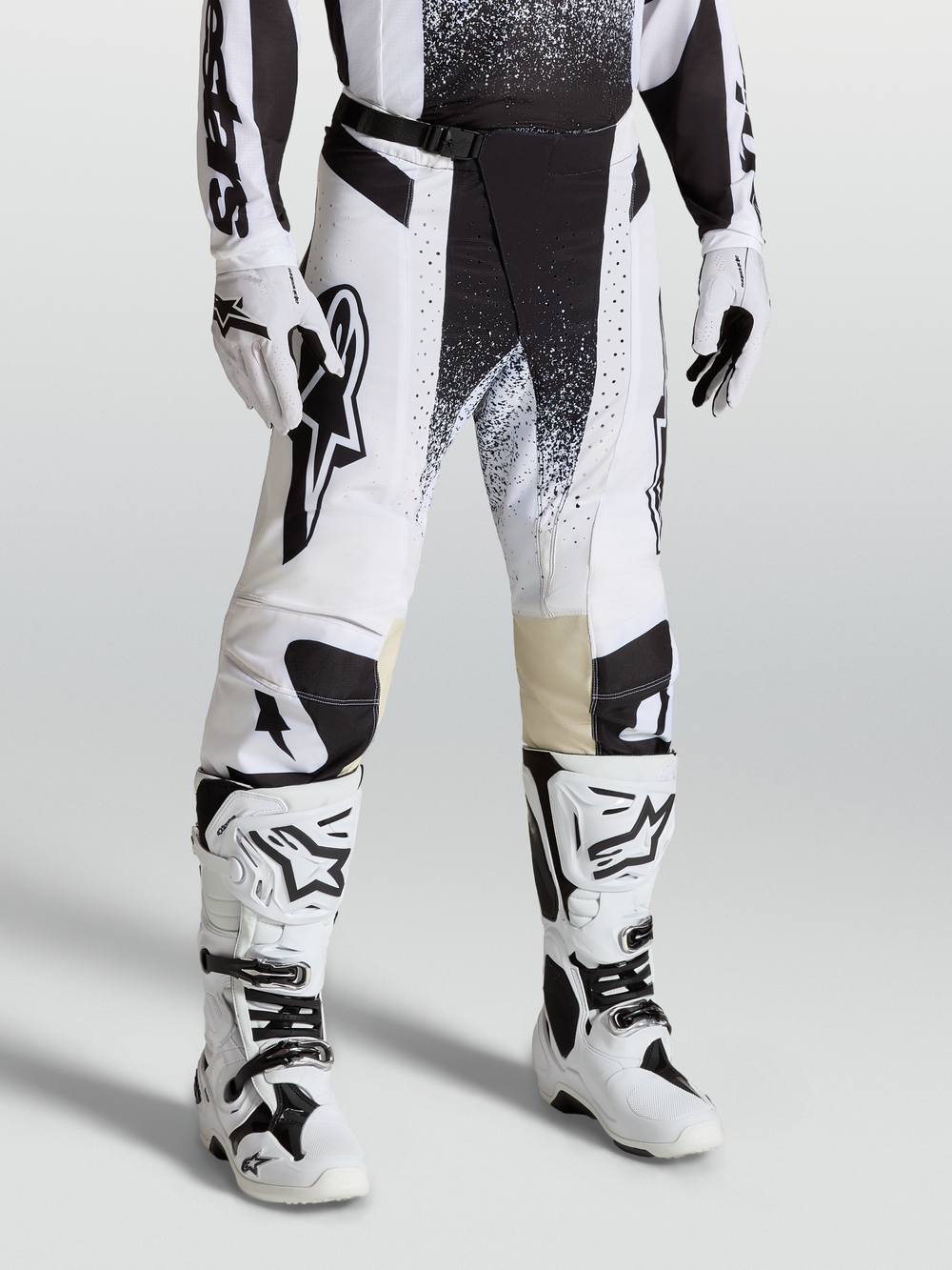 Alpinestars Techstar Swan Motocross Pants, White and Black race-fit gear on-model with matching boots, high-performance stretch ripstop design.
