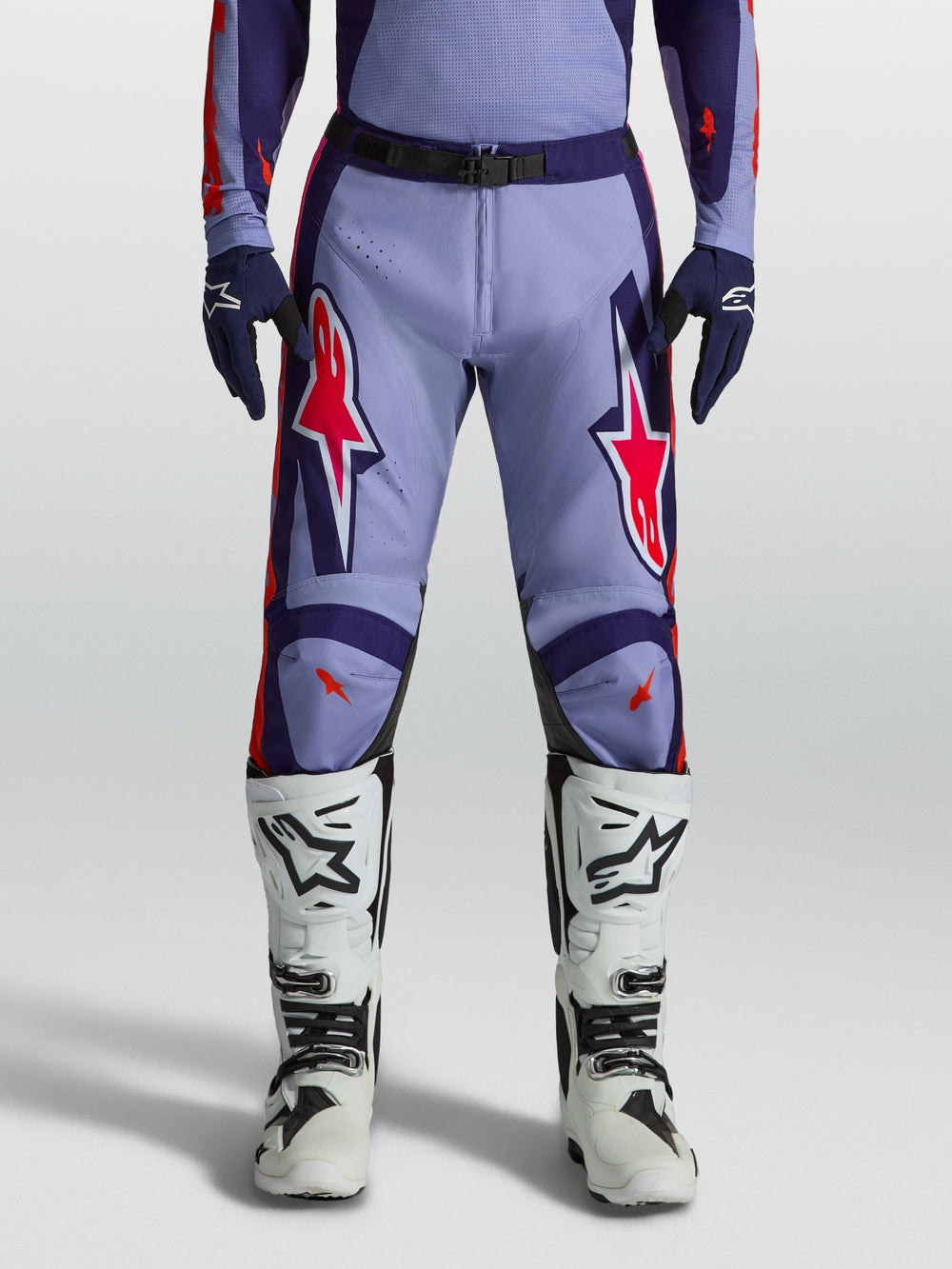 Alpinestars Racer Air Hunt Motocross Pants in light violet and deep purple with pink fluo accents, worn with white boots.