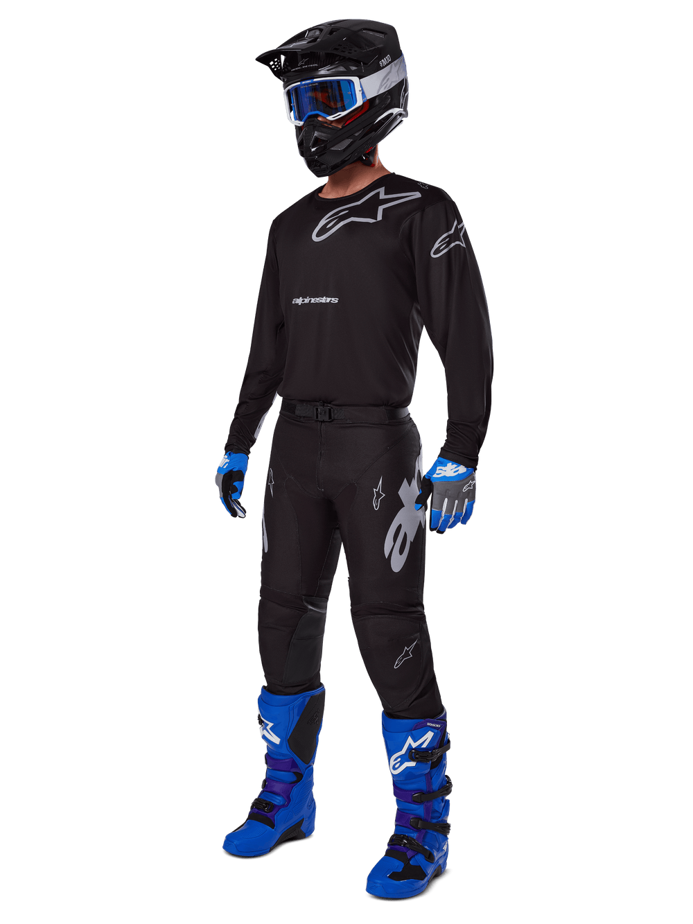 Motocross rider wearing complete Alpinestars racing gear, 2025 Racer Graphite Pants in Black and Gray, matching black jersey with grey logos, black helmet with blue goggles, bright blue and purple boots, and blue and grey gloves, coordinated outfit for off-road racing