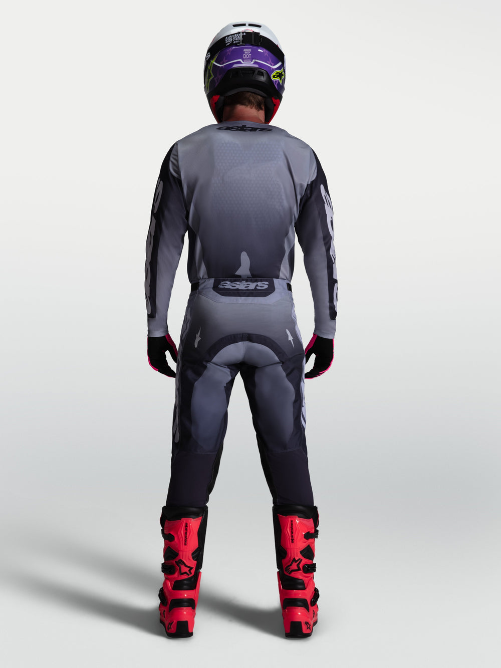 Alpinestars Racer Amber Pants, gray and light lilac motocross gear set for men, back view with red boots.