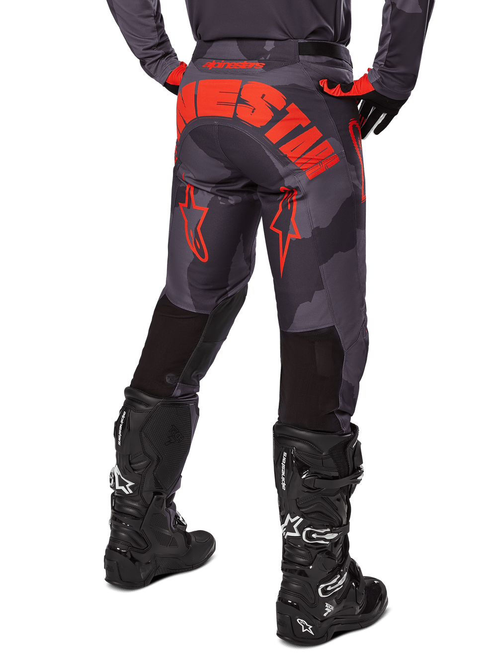 Rear view of Alpinestars 2025 Racer Hollow Pants, Motocross Pants, Gray Camo and Orange Fluo, featuring bold orange branding across the seat and back of legs, worn with black motocross boots and matching jersey, designed for off-road performance.