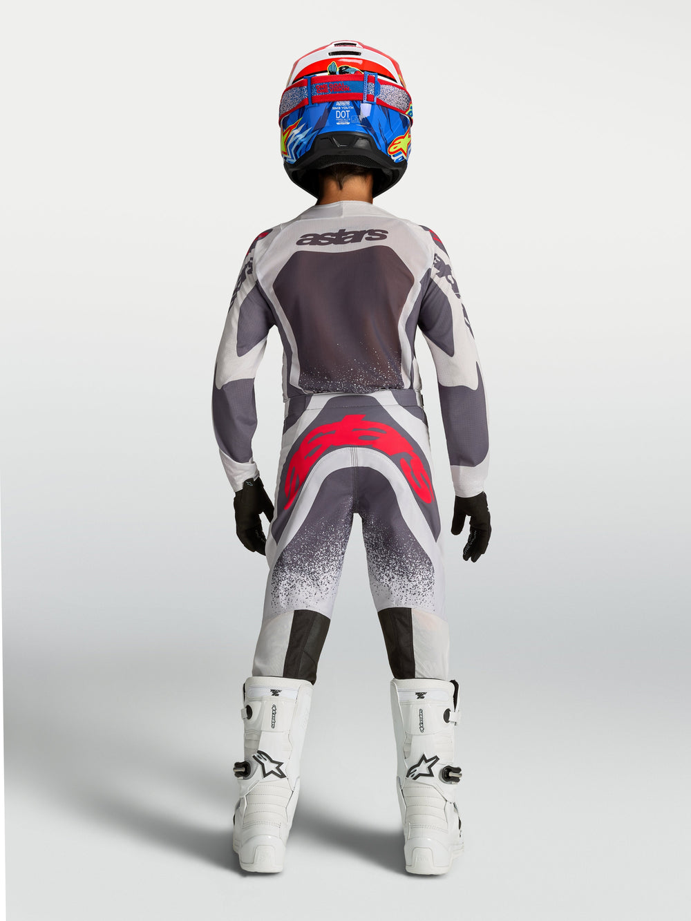 Alpinestars Youth Supertech Swan Pants, gray and red fluo youth motocross racing gear shown from the rear.