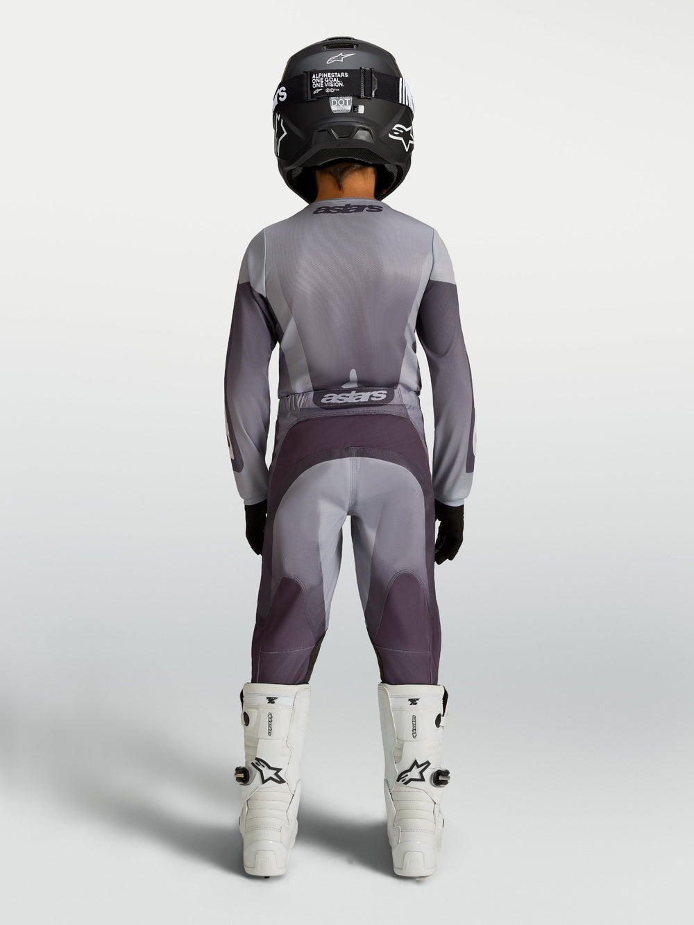 Alpinestars Youth Fluid Amber Pants in sand and gray, durable youth motocross pants shown from behind on a rider.