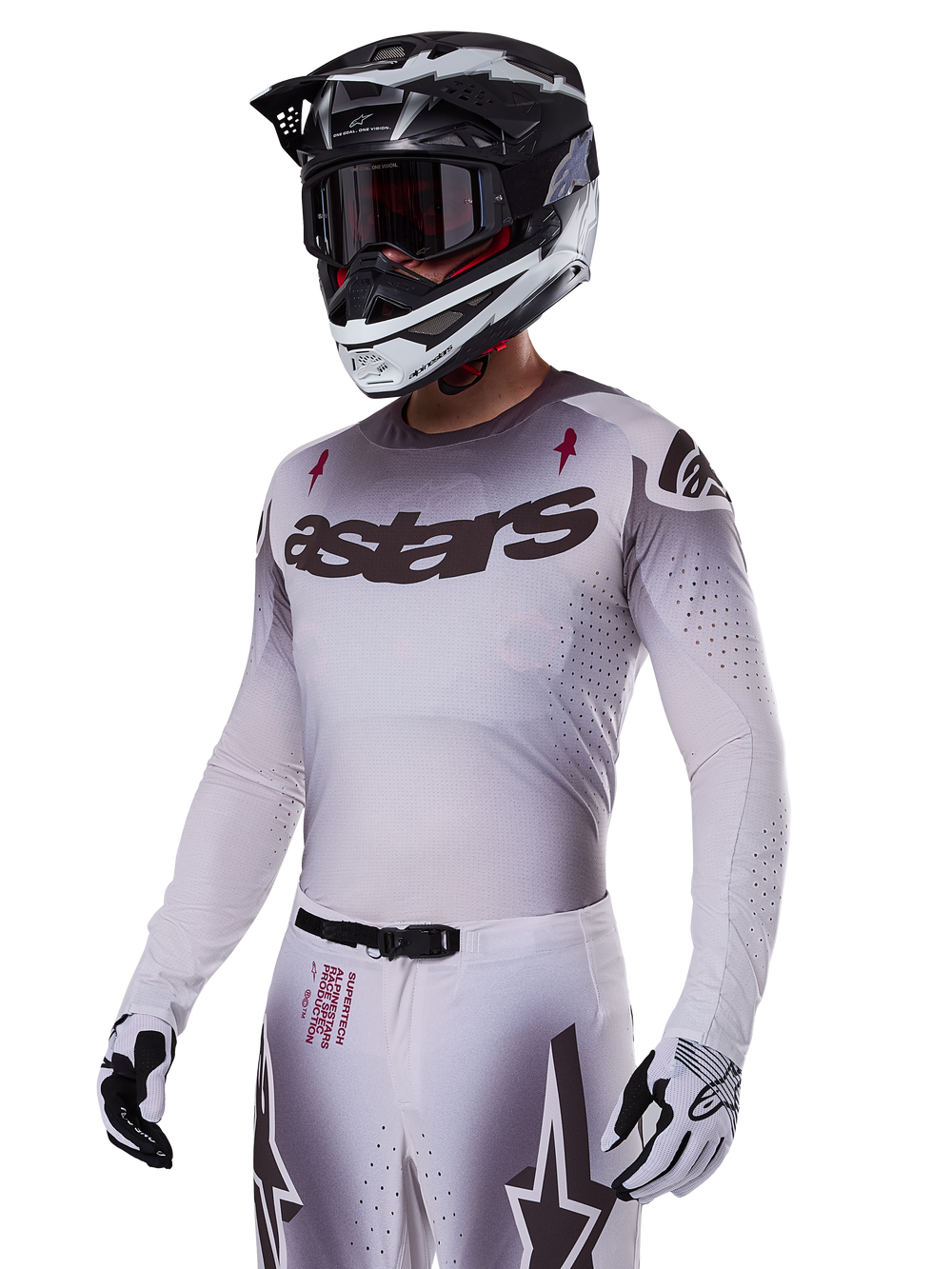 Alpinestars 2025 Supertech Maker Jersey, Motocross Racing Jersey, Silver and Black gradient, breathable stretch mesh with laser-cut perforations, worn with matching pants and helmet, featuring 'astars' branding, complete professional off-road gear