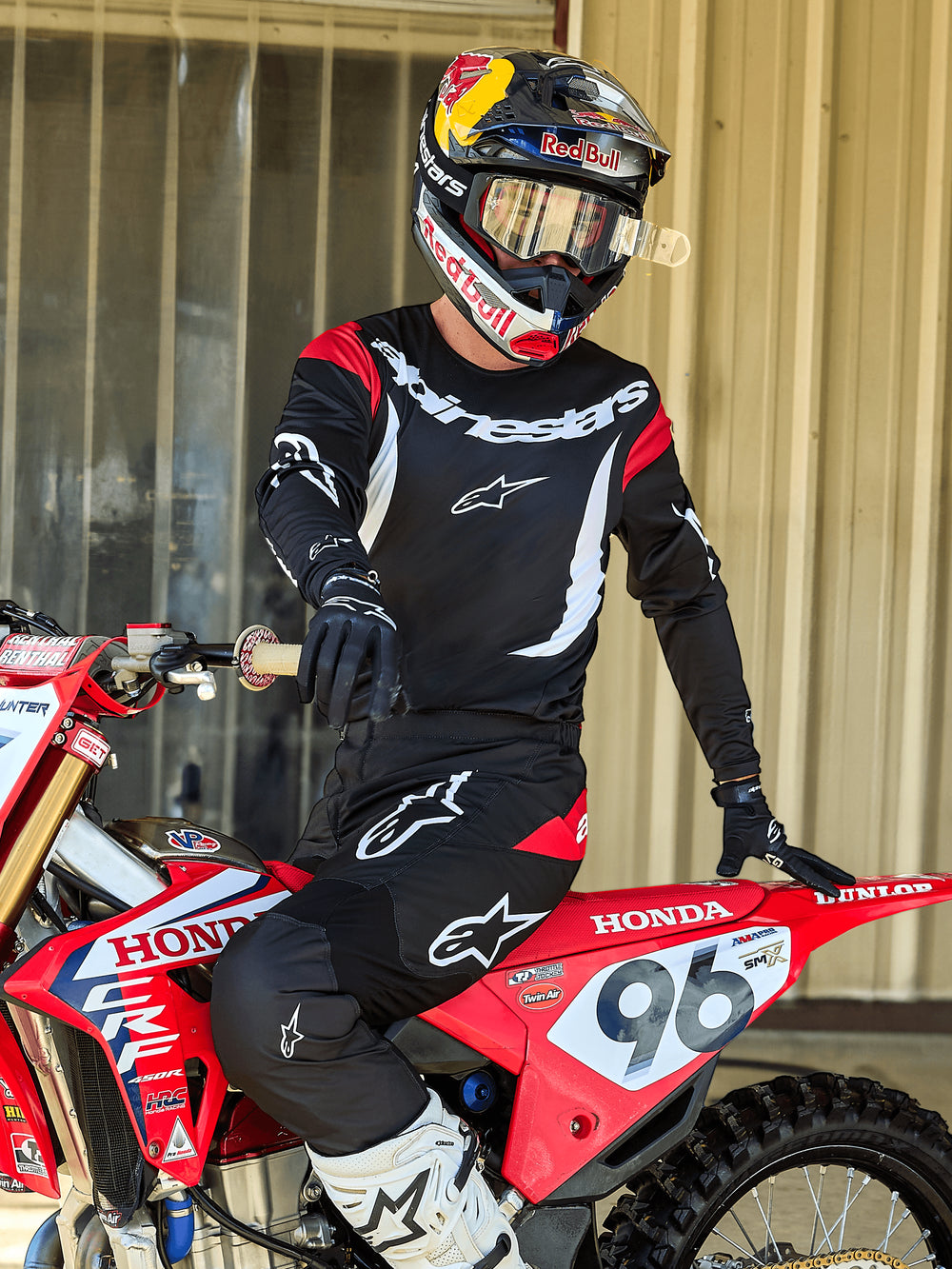 Alpinestars 2025 Fluid Haul Jersey in Black and White, men's performance motocross gear worn by a rider on a red Honda bike.