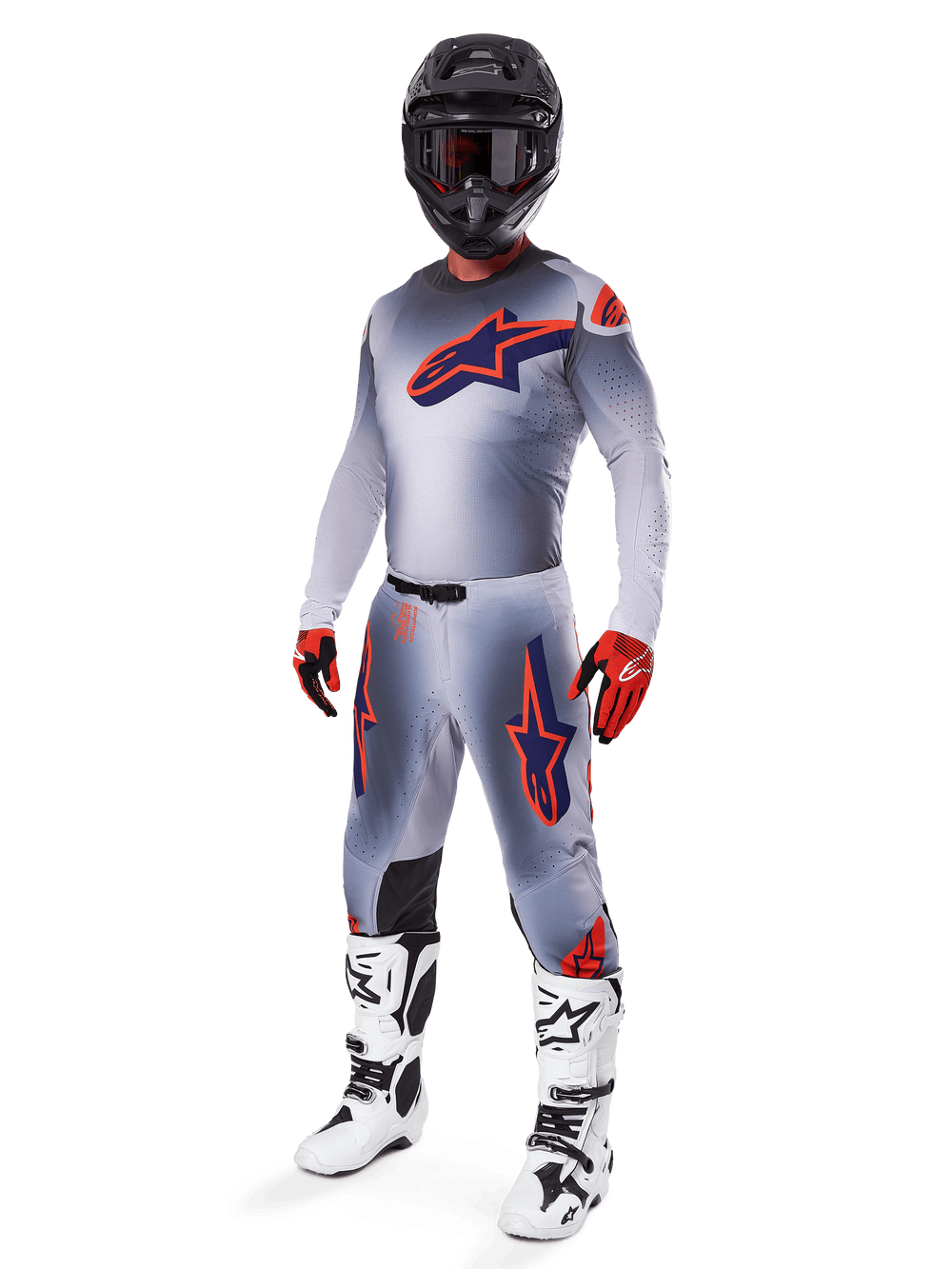 Motocross rider wearing the Alpinestars 2025 Supertech Lipan Jersey in Gray and Orange Fluo, matching gray pants with orange accents, black helmet, white and black boots, and orange and black gloves, professional gear set for off-road racing