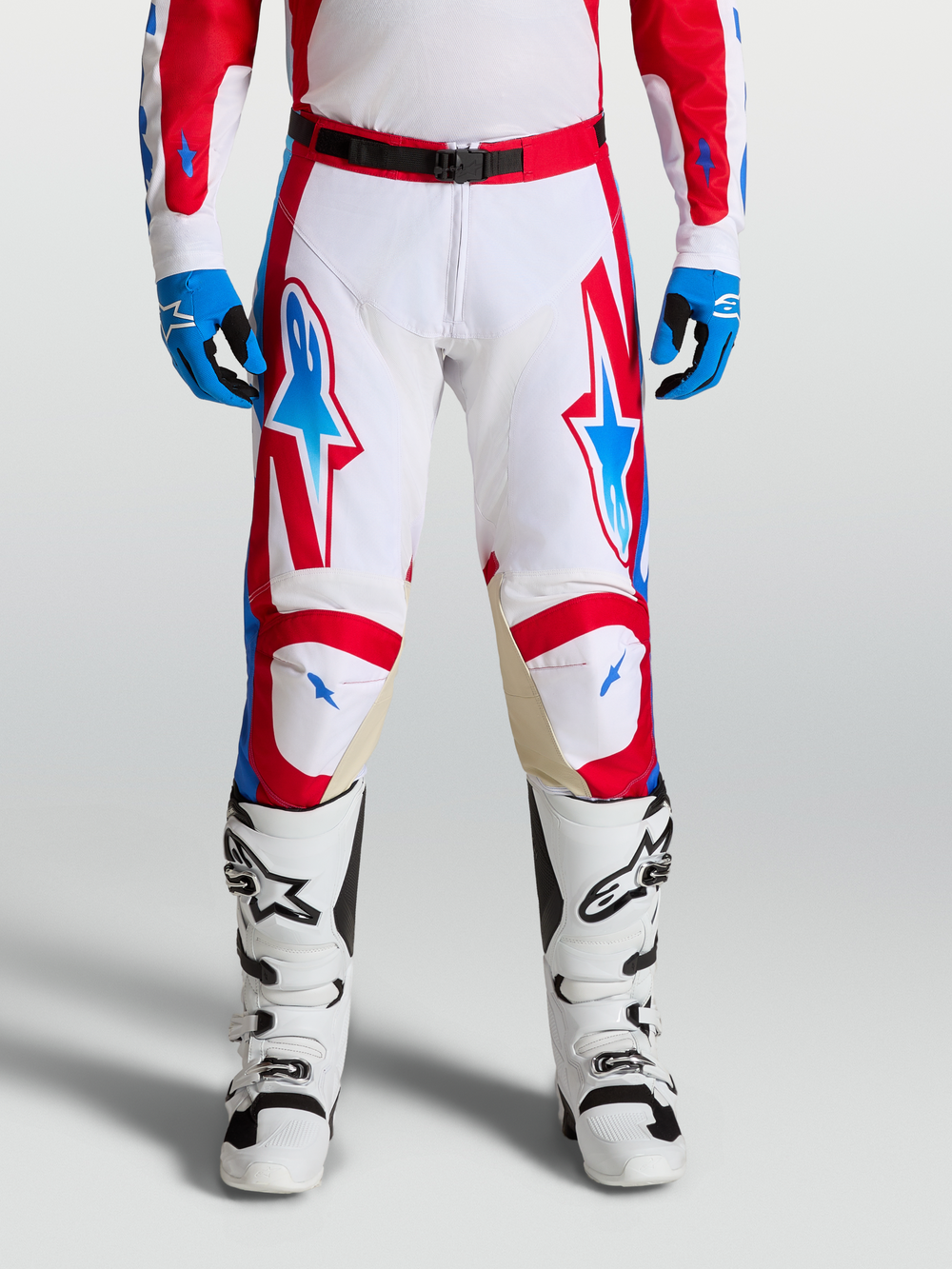 Alpinestars Racer Hunt Pants, performance motocross racing pants in white, fire red, and blue with ergonomic pre-curved legs and leather knee panels.