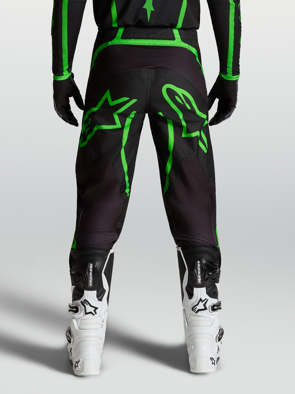 Alpinestars Fluid Apex V2 Pants, Men's Motocross Pants in Black and Fluo Green with large star graphics, rear view on-model.