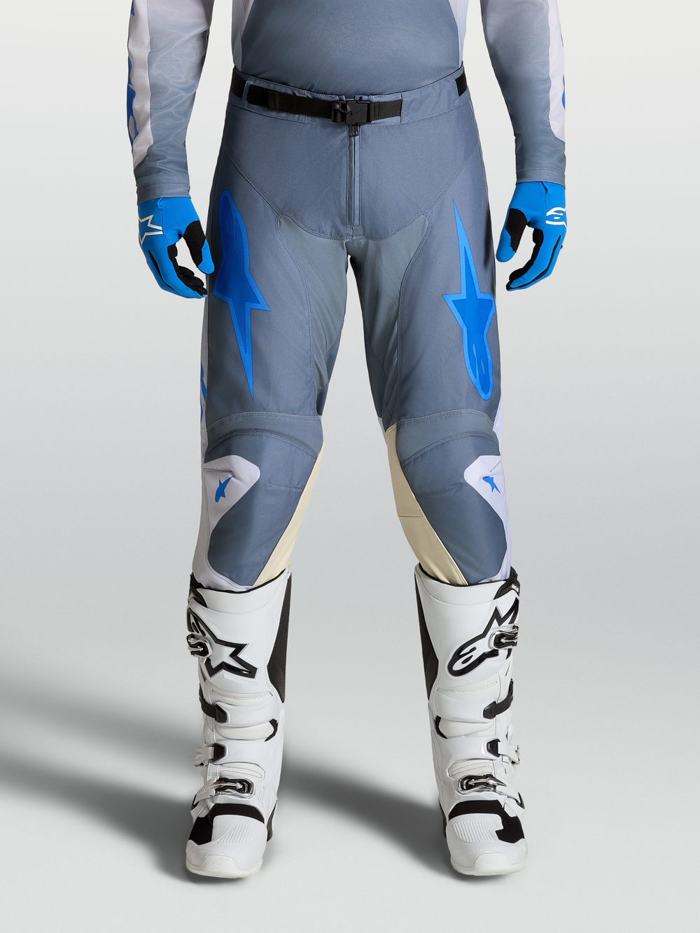 Alpinestars Racer Amber Pants, Men's Motocross Gear in Ash Gray and UCLA Blue, shown on-model with white racing boots.