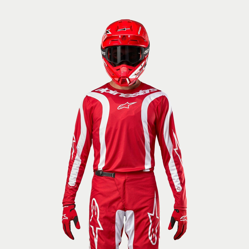 Alpinestars 2024 Fluid Lurv Jersey, Motocross Jersey, Mars Red and White, worn with matching red pants, helmet, and gloves, featuring white graphic accents on the sleeves and bold chest branding, athletic fit for off-road racing