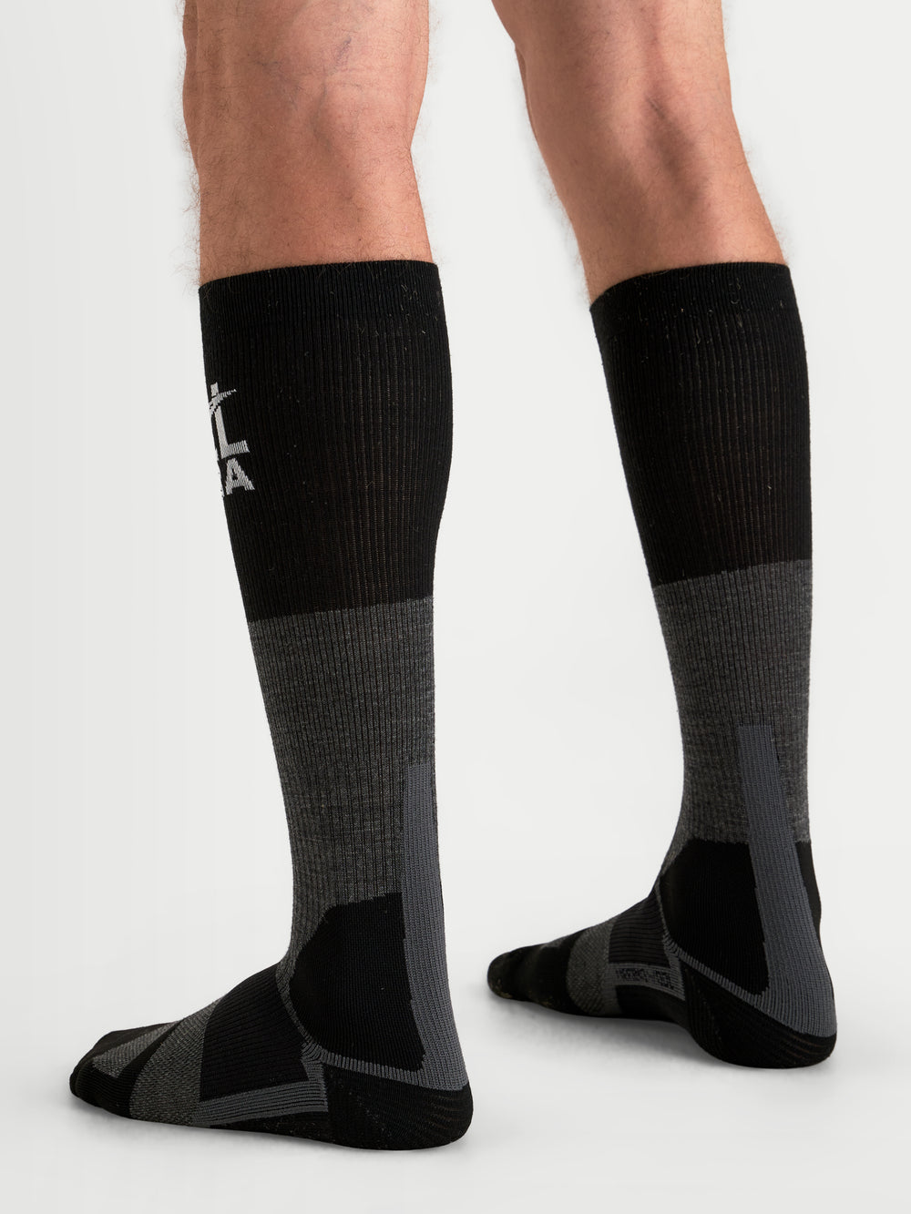 Alpinestars AT-8 Merino Socks, adventure motorcycle socks worn on a model, tar gray and black, over-the-calf thermal performance gear with reinforced cushioning