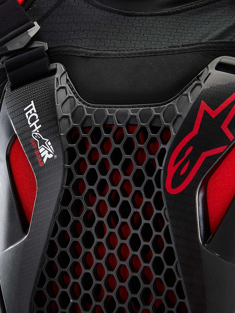 Alpinestars Tech-Air Off-Road System, off-road motorcycle airbag system close-up detail, Black and Red, featuring Nucleon CELL honeycomb chest protection, Tech-Air branding, and breathable stretch-mesh chassis