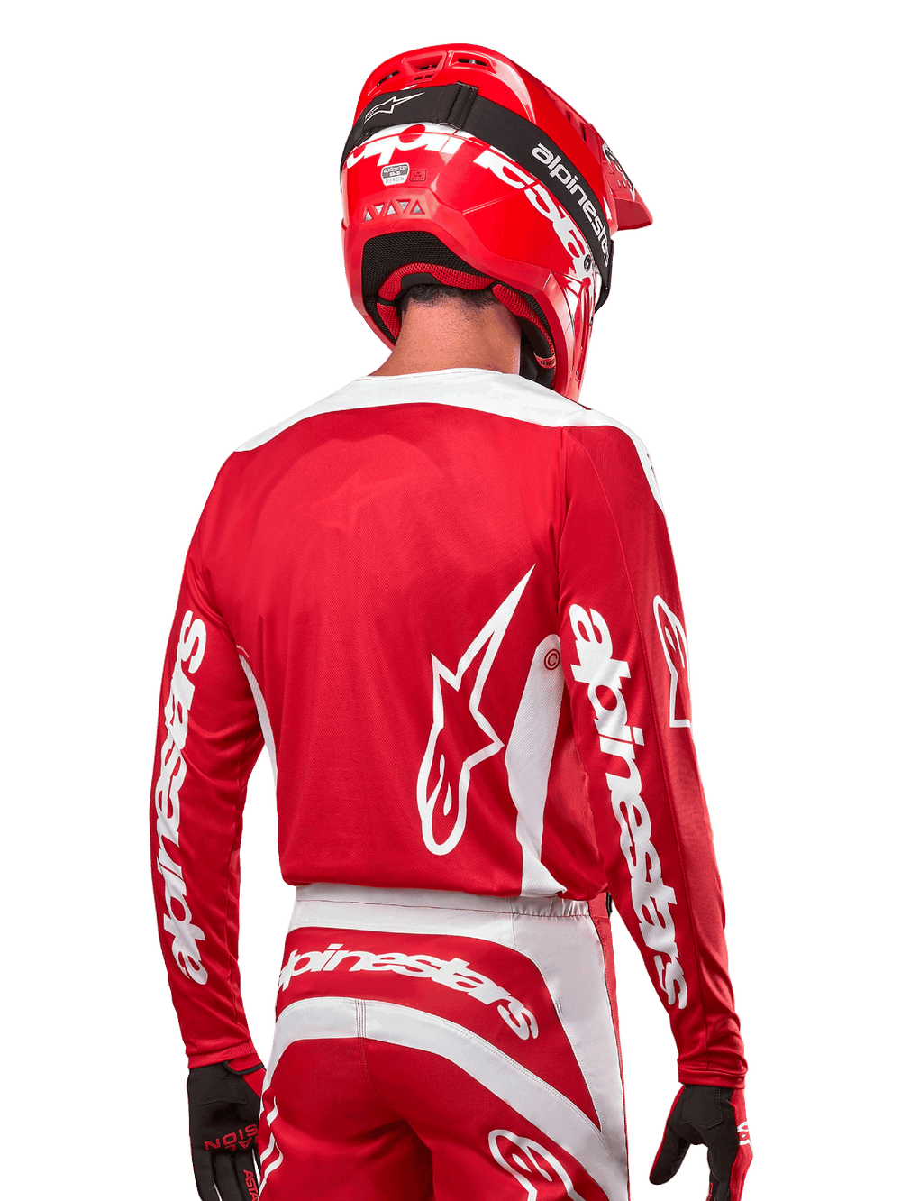 Motocross rider wearing Alpinestars 2024 Fluid Lurv Jersey, Mars Red and White, rear view showing white Alpinestars logo on back and branding on sleeves, paired with a matching red helmet and black gloves, professional off-road racing gear