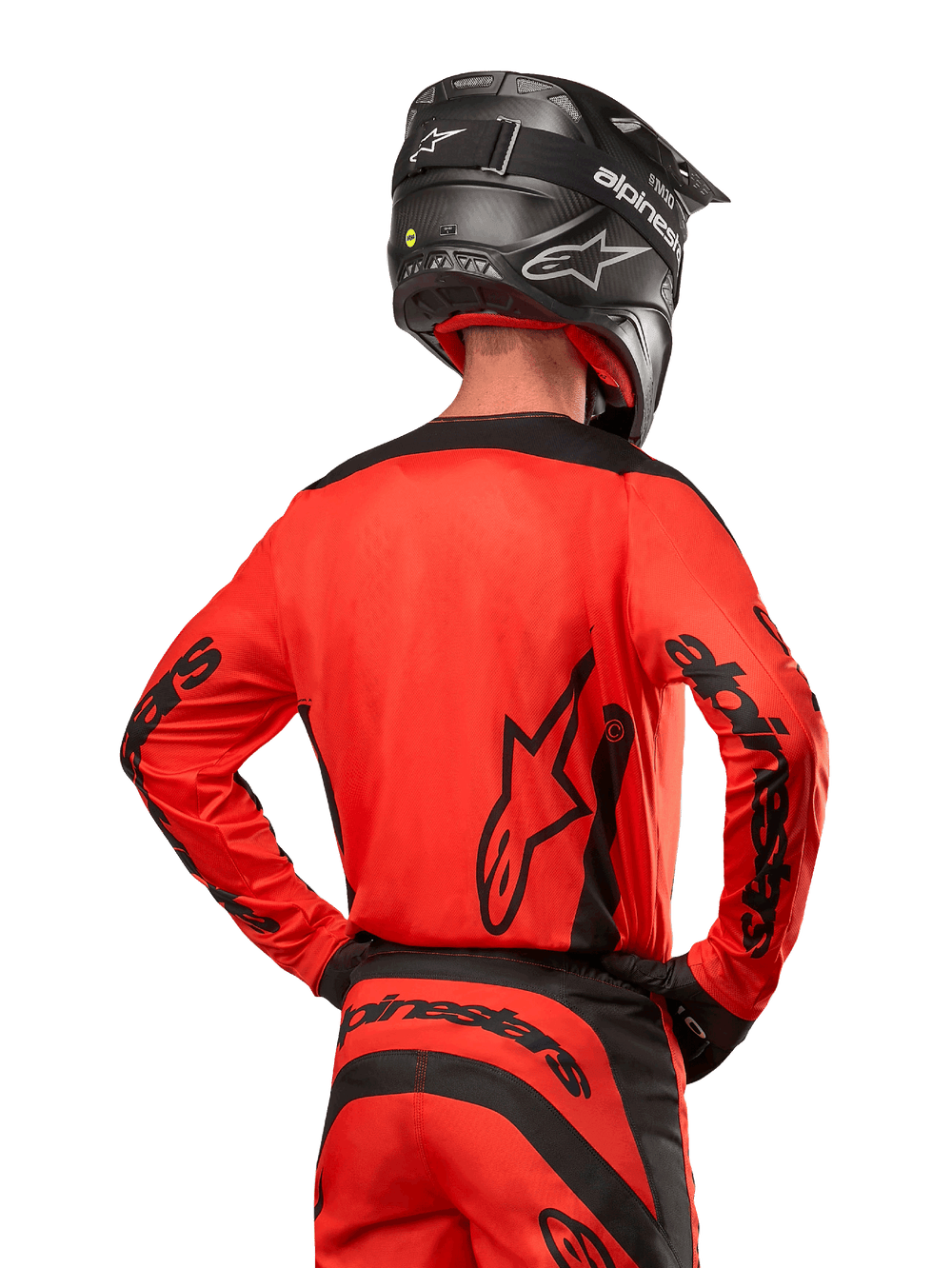Motocross rider from behind wearing the Alpinestars 2024 Fluid Lurv Jersey in Hot Orange and Black, featuring bold Alpinestars branding on the back and sleeves, paired with matching motocross pants and a black helmet, designed for off-road racing performance.