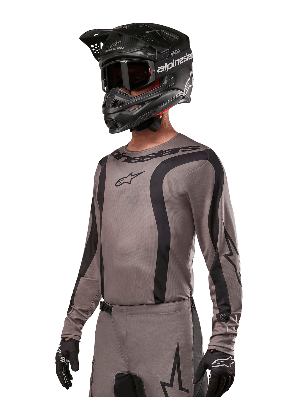 Alpinestars 2024 Fluid Lurv Jersey, Motocross Jersey, Mud Black and Gray, long-sleeve design with curved black stripes and logos, worn with matching pants and a black motocross helmet, coordinated off-road racing setup